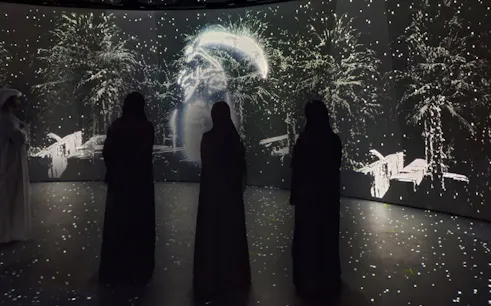 Visitors observing digital art display at Diya Experience, Sheikh Zayed Grand Mosque Centre.