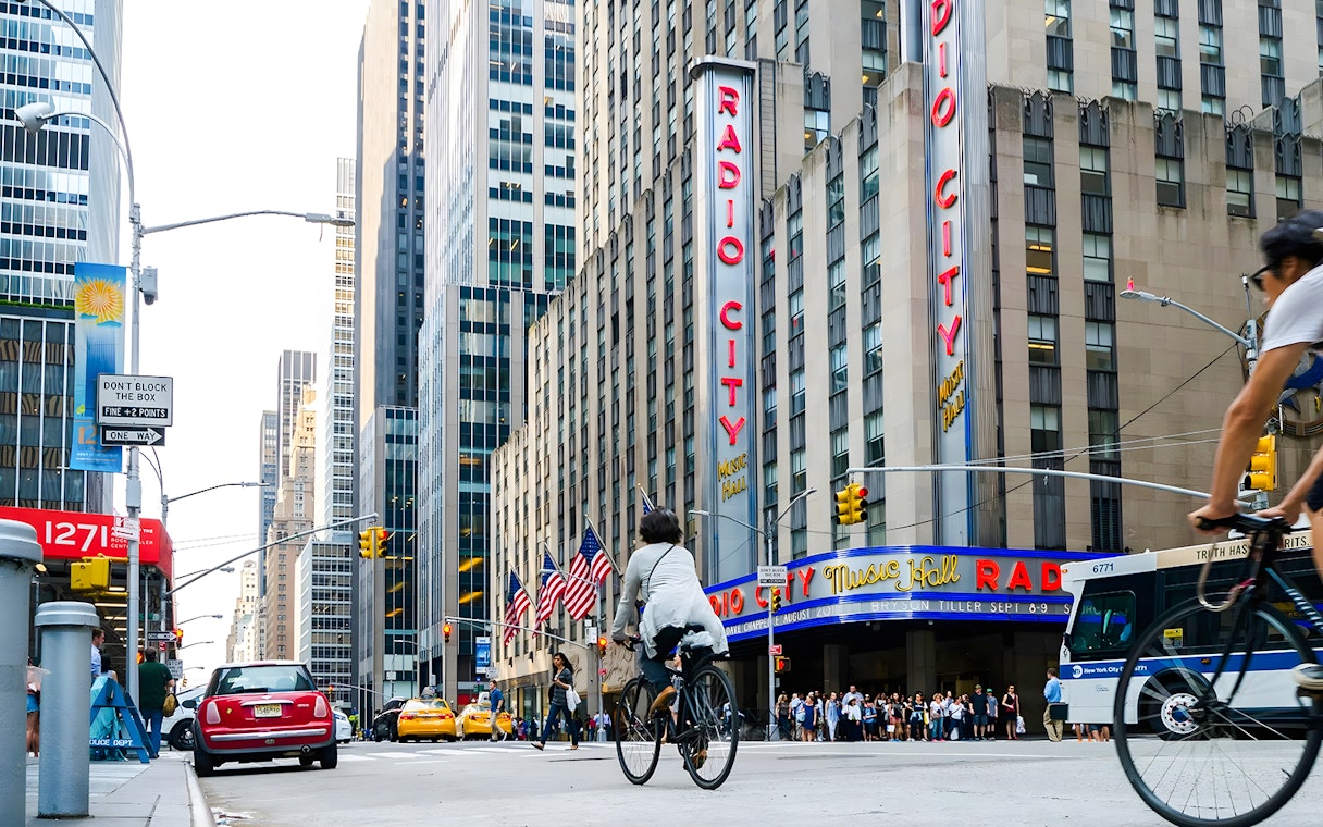 Cyclist passing by Radio City Music Hall in New York City.
