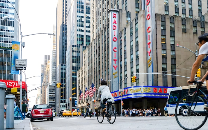 Cyclist passing by Radio City Music Hall in New York City.