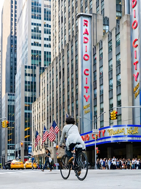 Cyclist passing by Radio City Music Hall in New York City.