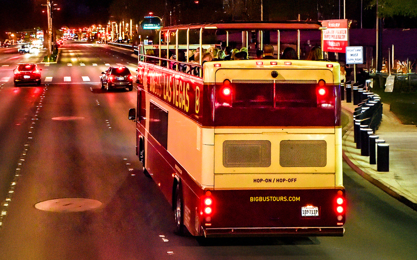 Open-top Big Bus Tours vehicle on Las Vegas Strip at night.