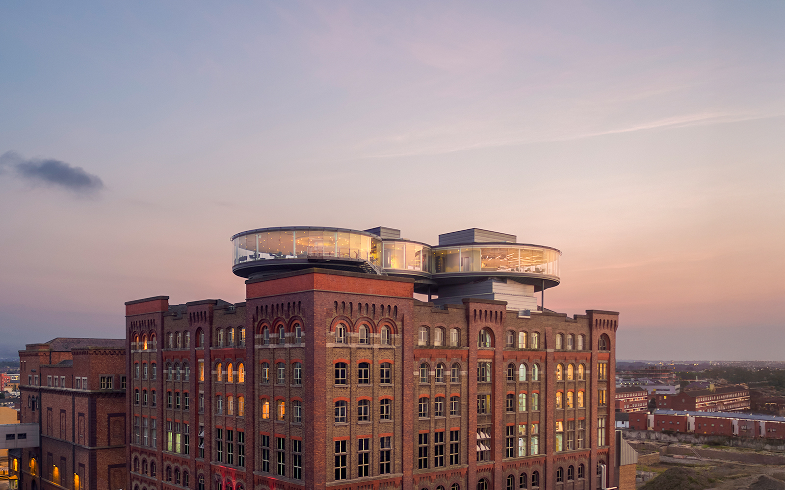 Guinness Storehouse exterior with glass rooftop at sunset in Dublin, Ireland.