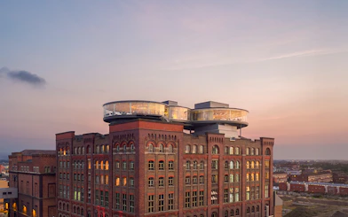 Guinness Storehouse exterior with glass rooftop at sunset in Dublin, Ireland.