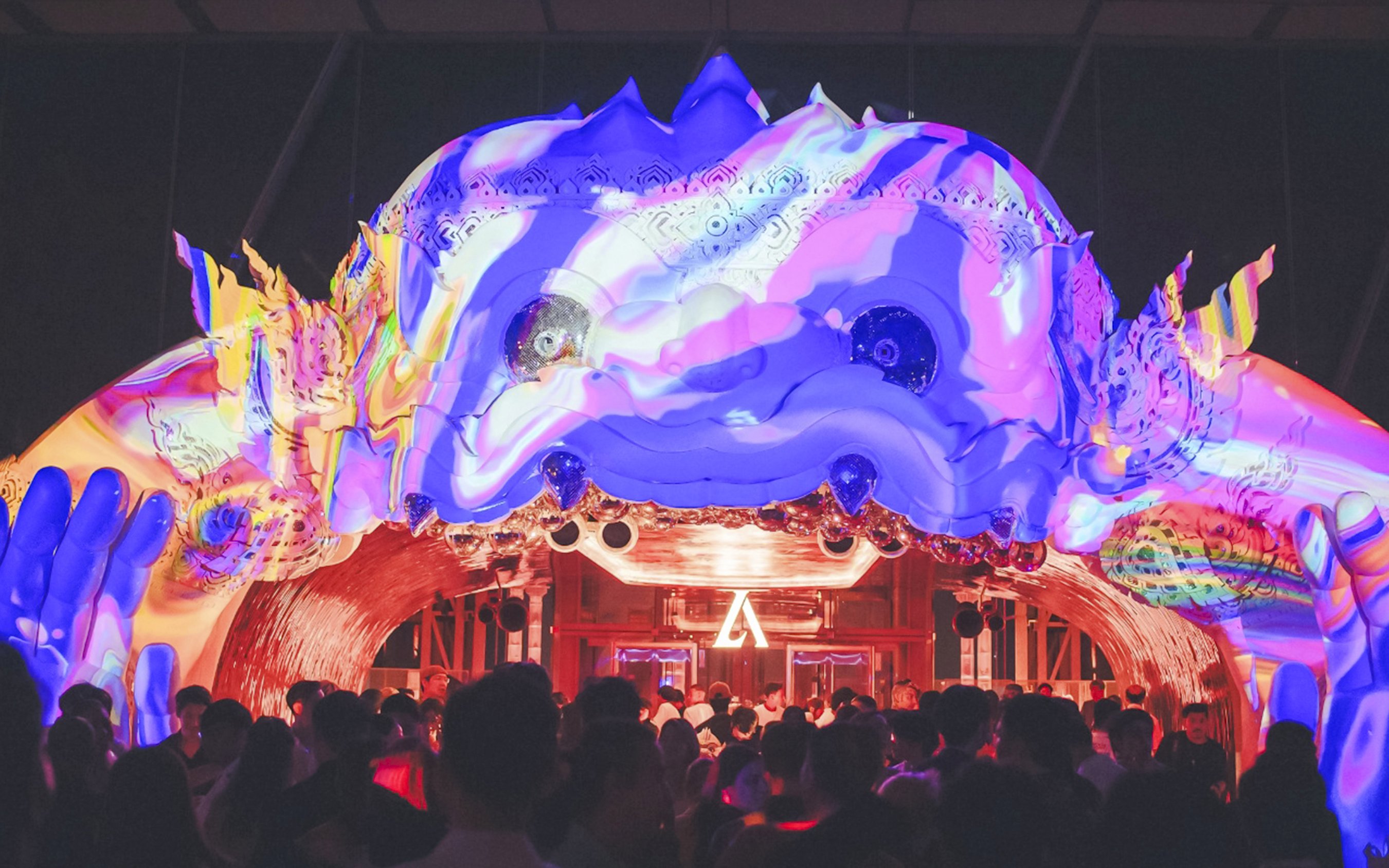 Hanuman sculpture with colorful projection mapping at night event.