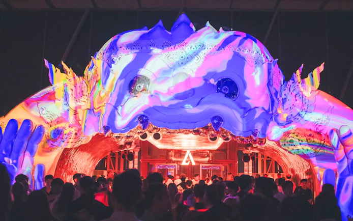 Hanuman sculpture with colorful projection mapping at night event.