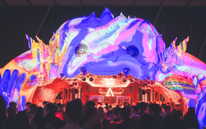 Hanuman sculpture with colorful projection mapping at night event.
