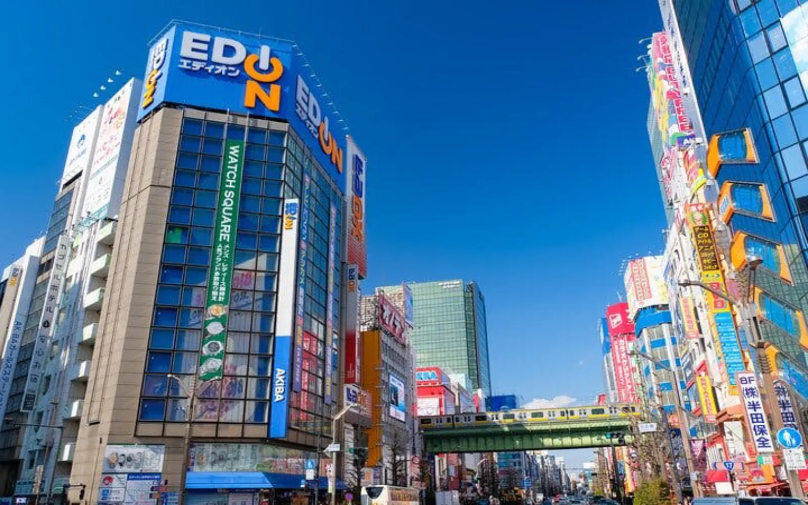 Akihabara district in Tokyo with colorful buildings and overhead train.