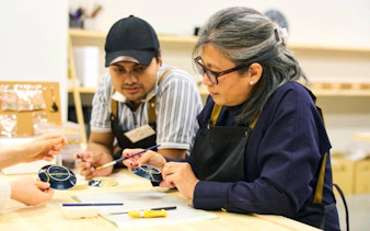 Participants learning Kintsugi at a workshop in Shinjuku, Tokyo, repairing pottery with gold.