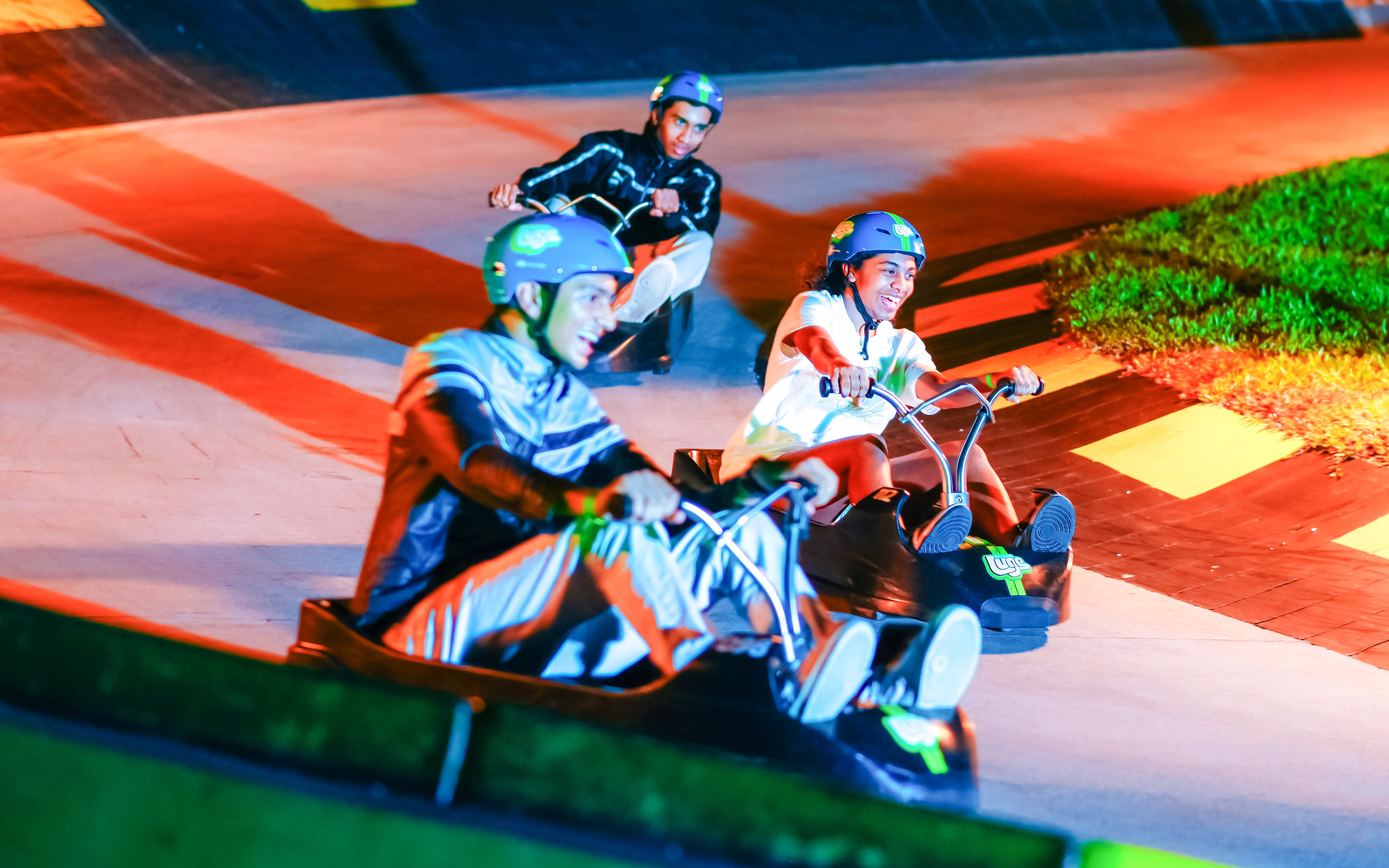 People enjoying a ride on the Skyline Luge track at night.