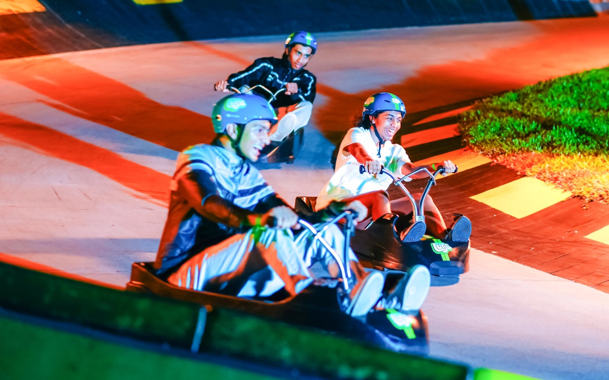 People enjoying a ride on the Skyline Luge track at night.