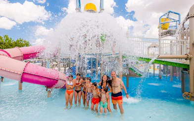 Visitors enjoying water slides and splash area at Parque Warner Beach in Madrid, Spain.