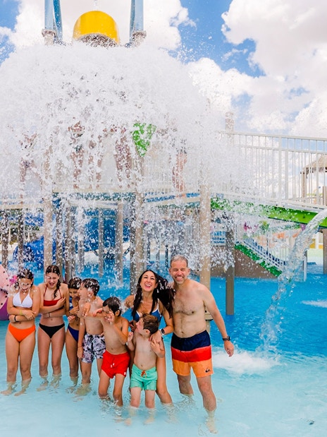 Visitors enjoying water slides and splash area at Parque Warner Beach in Madrid, Spain.