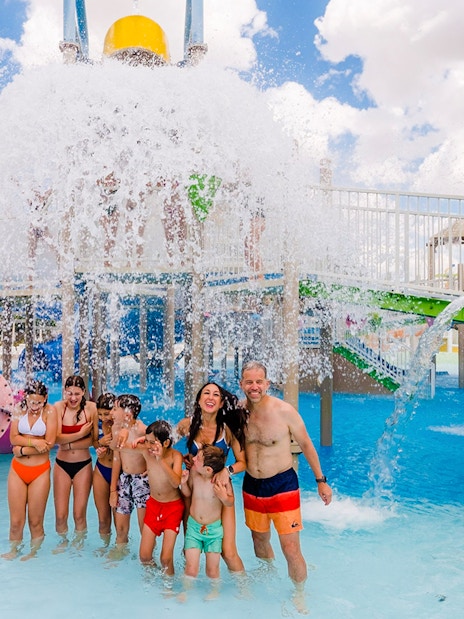 Visitors enjoying water slides and splash area at Parque Warner Beach in Madrid, Spain.