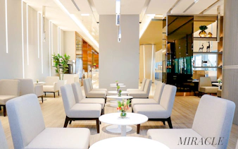 Miracle Lounge seating area at Bangkok airport, Thailand with modern decor and tables.