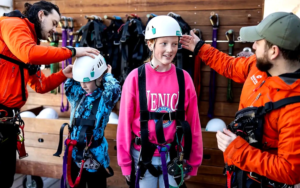 Children preparing for Rotorua Forest Zipline Tour with helmets and harnesses.