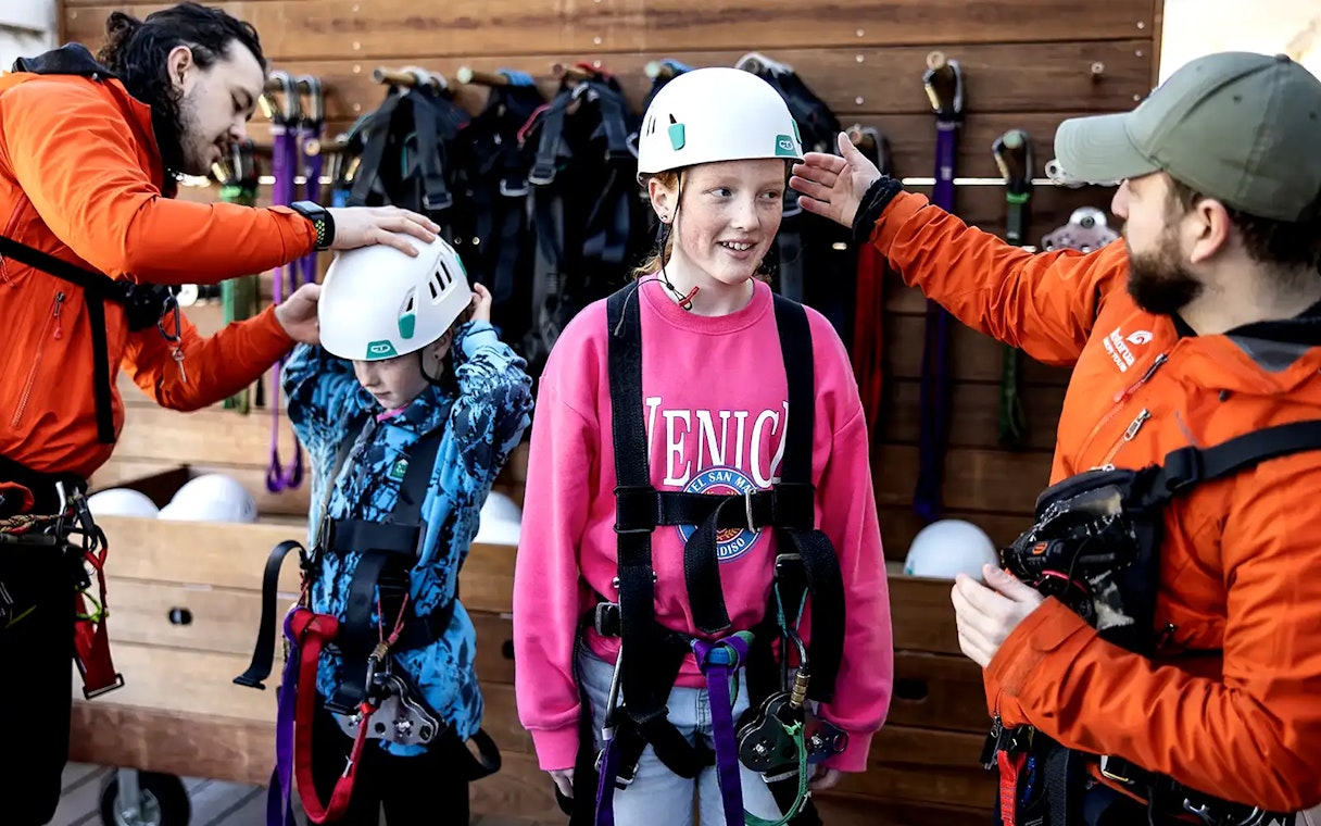 Children preparing for Rotorua Forest Zipline Tour with helmets and harnesses.