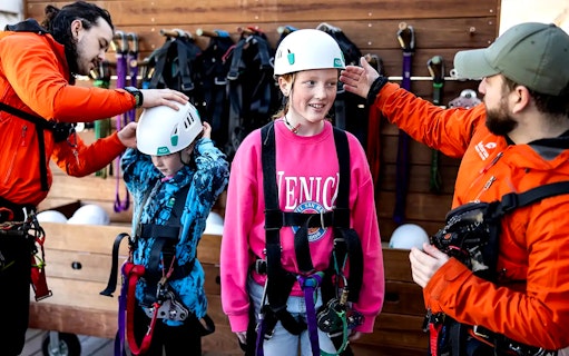 Children preparing for Rotorua Forest Zipline Tour with helmets and harnesses.