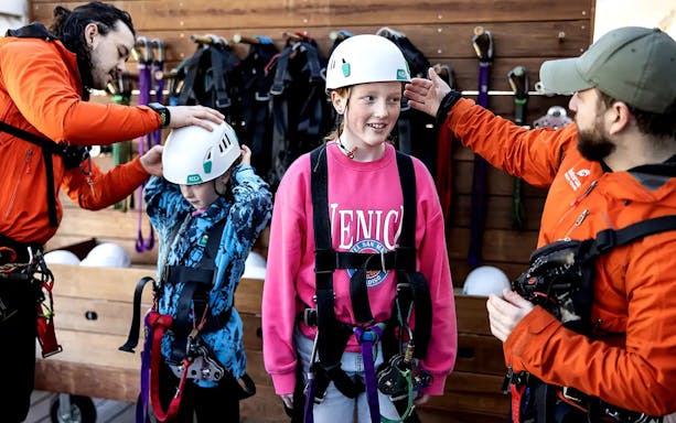 Children preparing for Rotorua Forest Zipline Tour with helmets and harnesses.