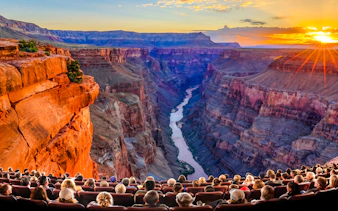 Audience watching Grand Canyon IMAX movie with canyon view and sunset.