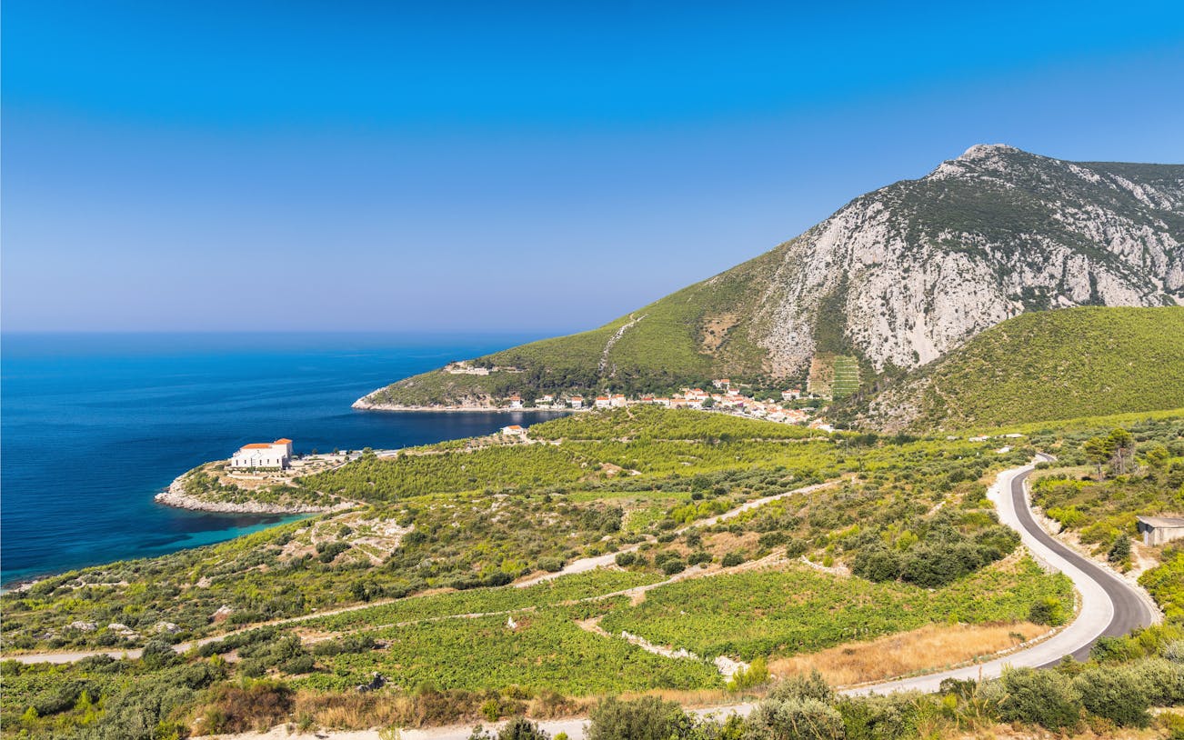 Sea coast view of Peljesac Peninsula, Croatia, with a winding road and coastal village.