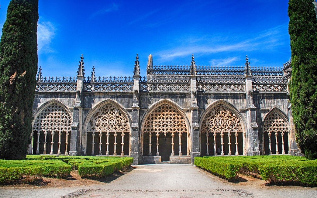 Batalha Monastery's ornate Gothic arches and manicured gardens in Portugal.