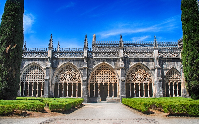 Batalha Monastery's ornate Gothic arches and manicured gardens in Portugal.