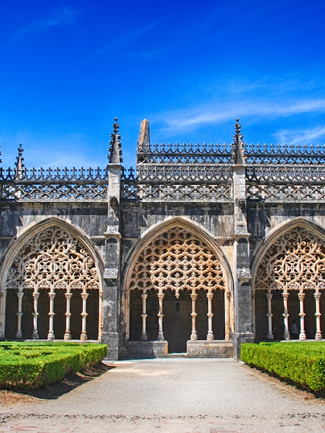 Batalha Monastery's ornate Gothic arches and manicured gardens in Portugal.