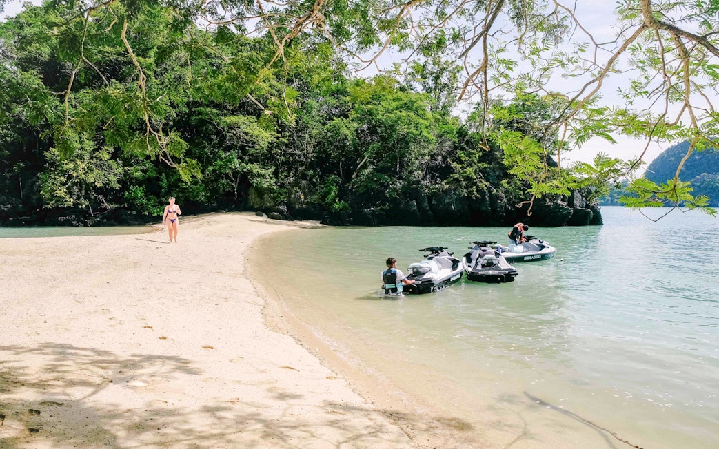 Jet skis on a sandy beach in Langkawi's UNESCO Kilim Geopark.