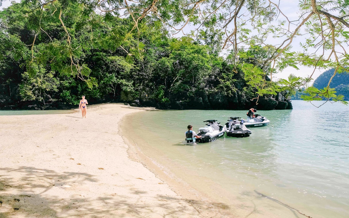 Jet skis on a sandy beach in Langkawi's UNESCO Kilim Geopark.