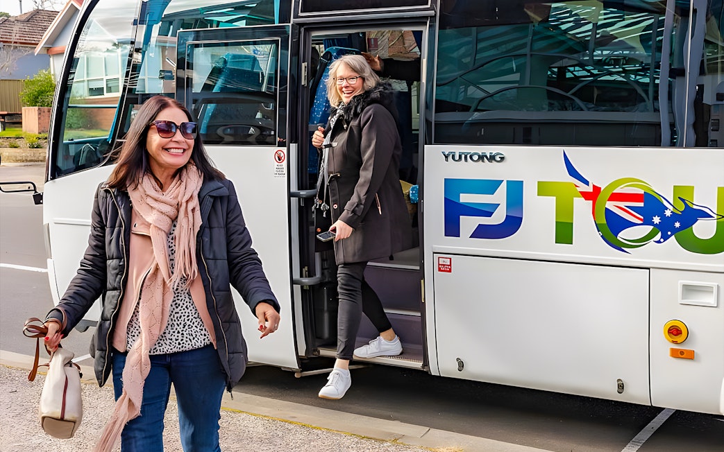 Tourists boarding a bus in Sydney for a full-day Blue Mountains tour.