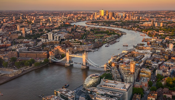 View of London from The Shard at sunset, featuring Tower Bridge and the Thames River.