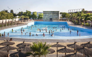 Visitors enjoying the wave pool at Agua Mágica, Isla Mágica, Seville.