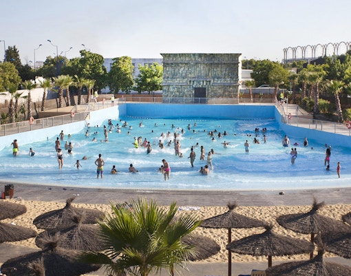 Visitors enjoying the wave pool at Agua Mágica, Isla Mágica, Seville.