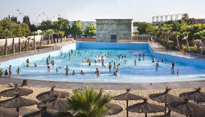 Visitors enjoying the wave pool at Agua Mágica, Isla Mágica, Seville.