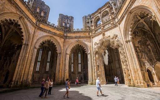 Visitors exploring the Gothic architecture of Batalha Monastery, Portugal.