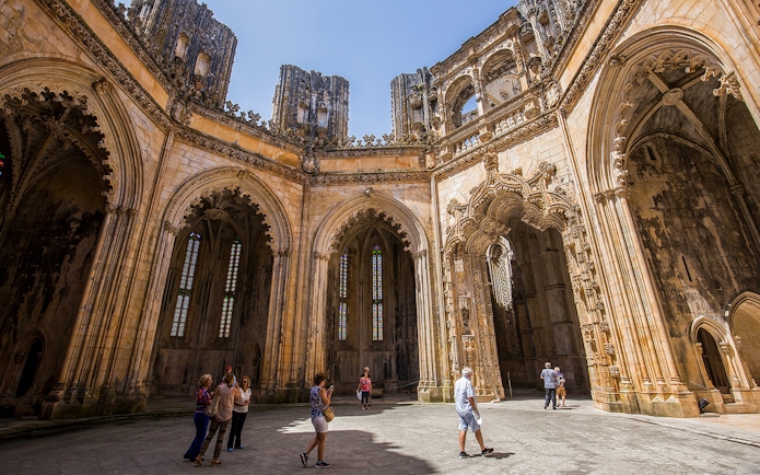 Visitors exploring the Gothic architecture of Batalha Monastery, Portugal.