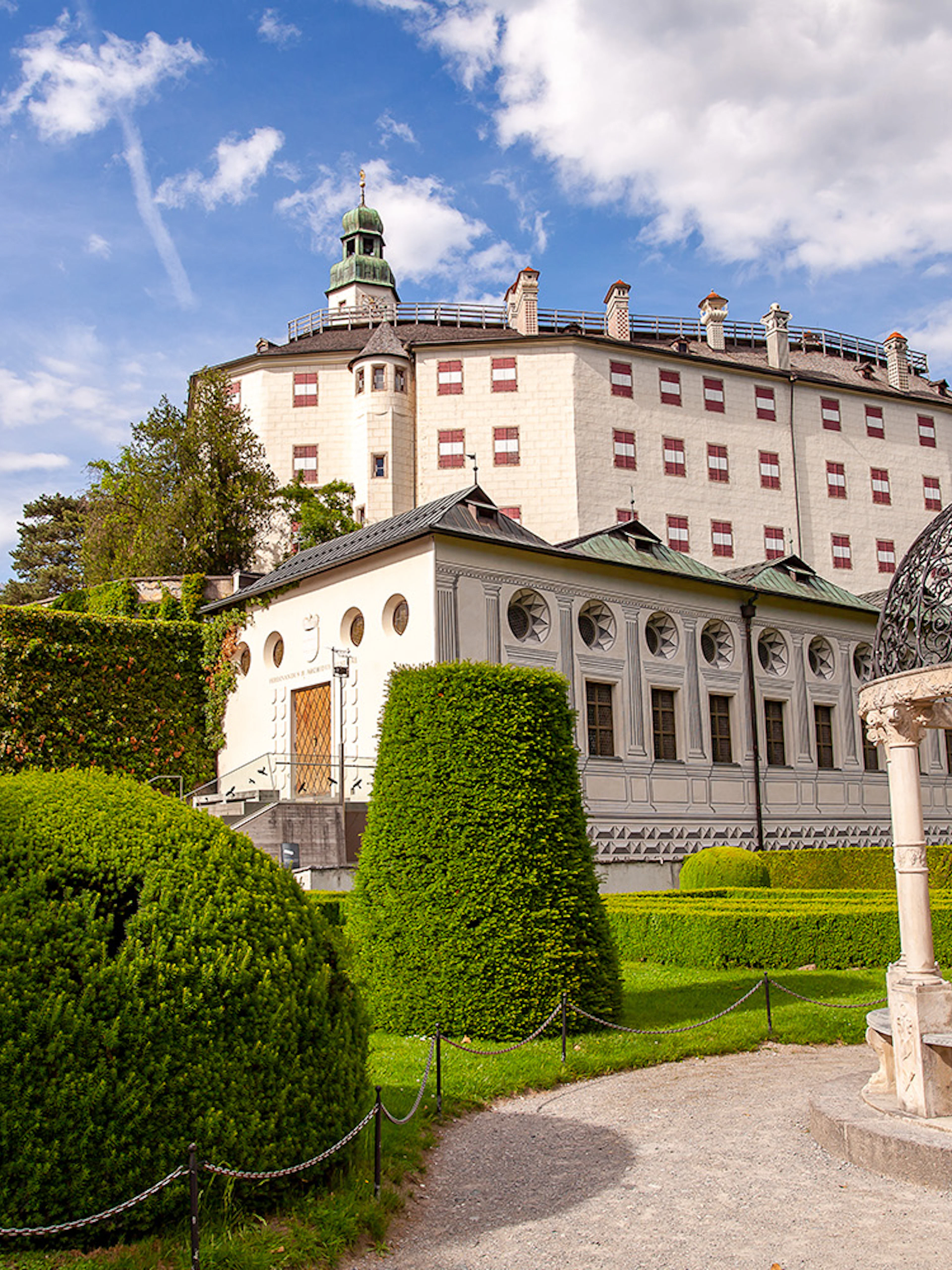 Ambras Castle Innsbruck with manicured gardens and ornate gazebo.