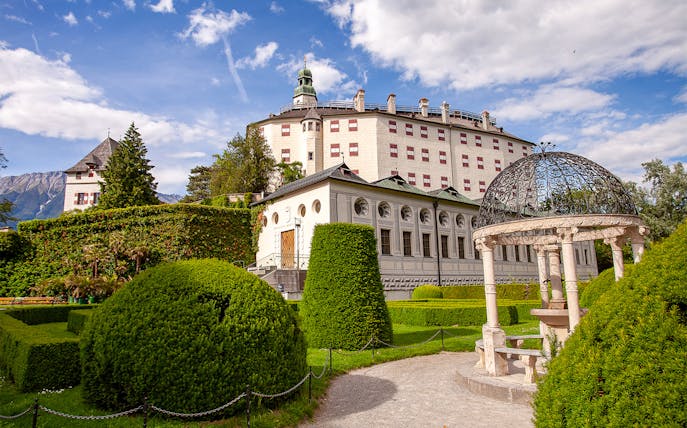 Ambras Castle Innsbruck with manicured gardens and ornate gazebo.