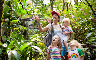 Family exploring lush greenery at Bali zoo.