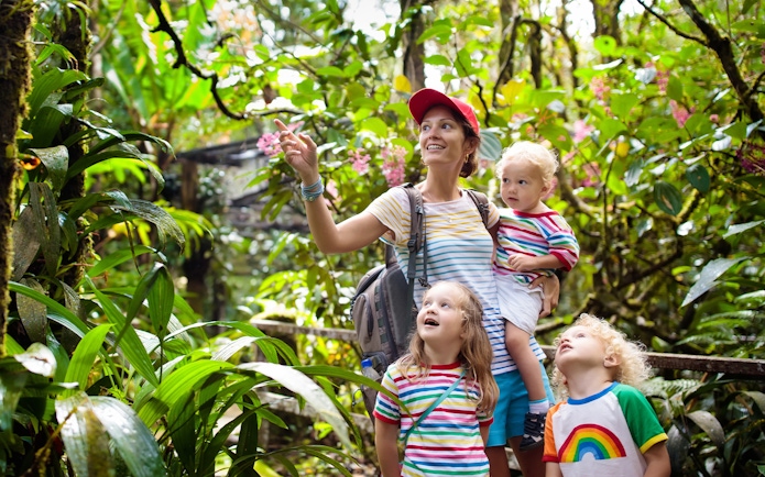 Family exploring lush greenery at Bali zoo.
