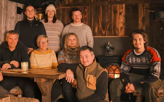 Small group of people in a cozy cabin during a snowmobile day trip in Tromso.