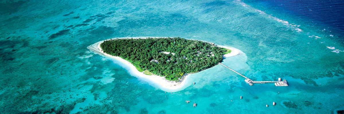 Green Island beach with palm trees and clear waters, Great Barrier Reef near Cairns, Queensland.
