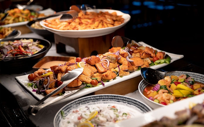Te Puia buffet with salmon, vegetables, and traditional dishes in Rotorua, New Zealand.