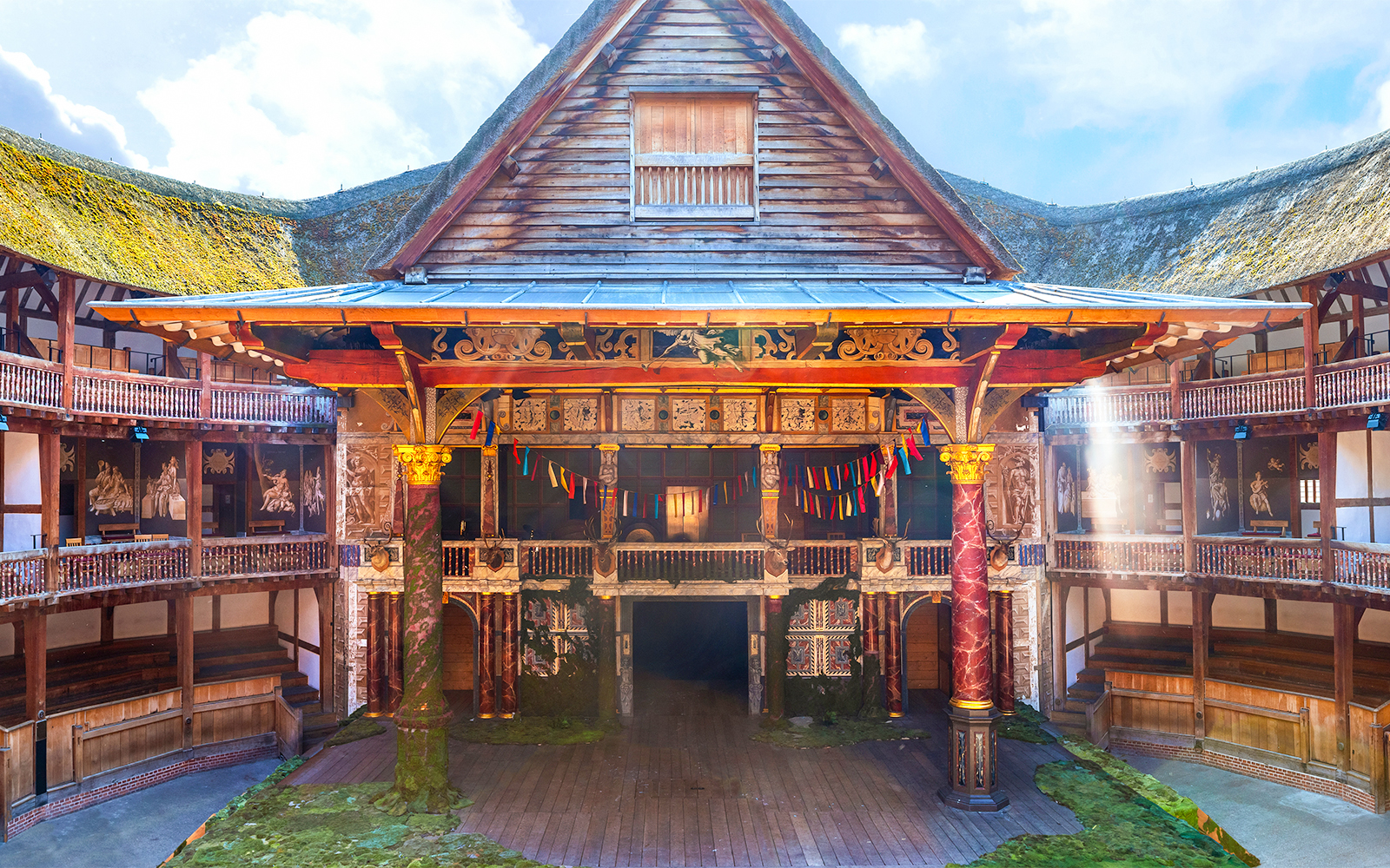Globe Theatre stage with colorful banners and wooden seating in London.