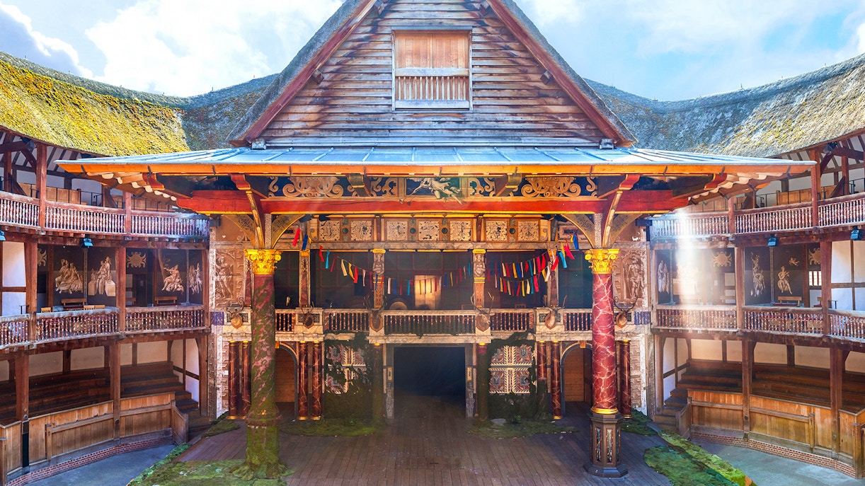 Globe Theatre stage with colorful banners and wooden seating in London.