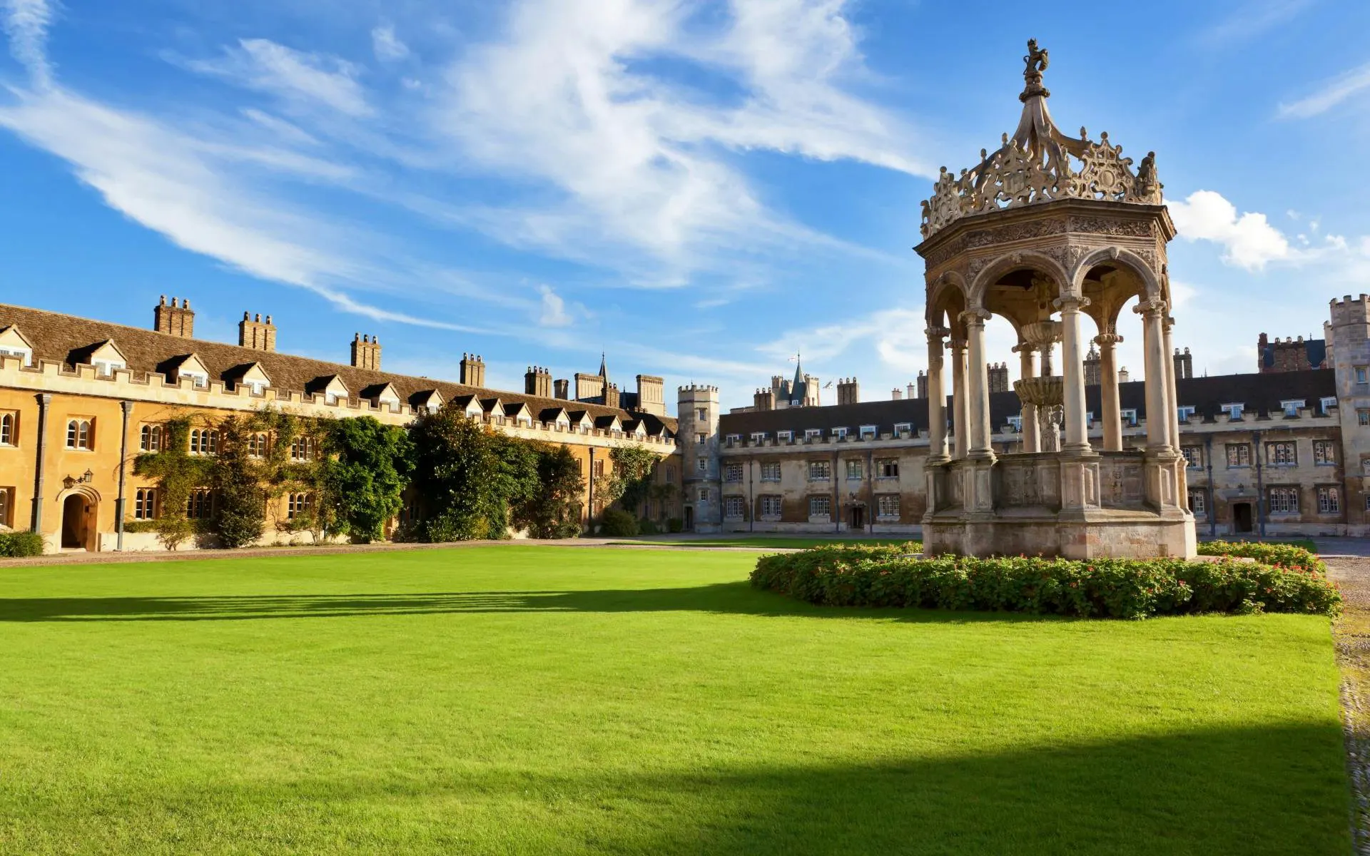 Great Court of Trinity College, Cambridge with ornate fountain and historic buildings.