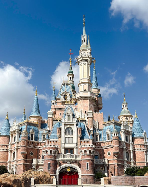 Enchanted Storybook Castle at Shanghai Disney Resort under a clear blue sky.