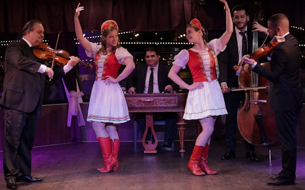Musicians and dancers performing traditional folk show on Budapest dinner cruise.
