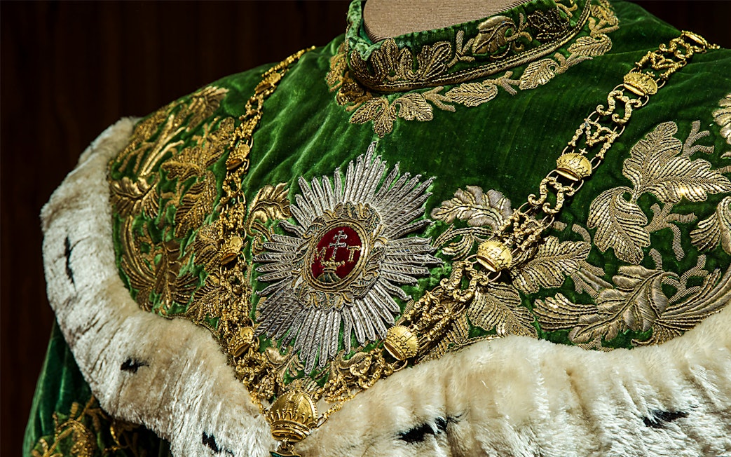 Ornate green and gold robe with intricate embroidery at Imperial Treasury Vienna.