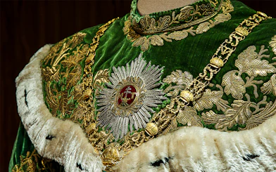 Ornate green and gold robe with intricate embroidery at Imperial Treasury Vienna.